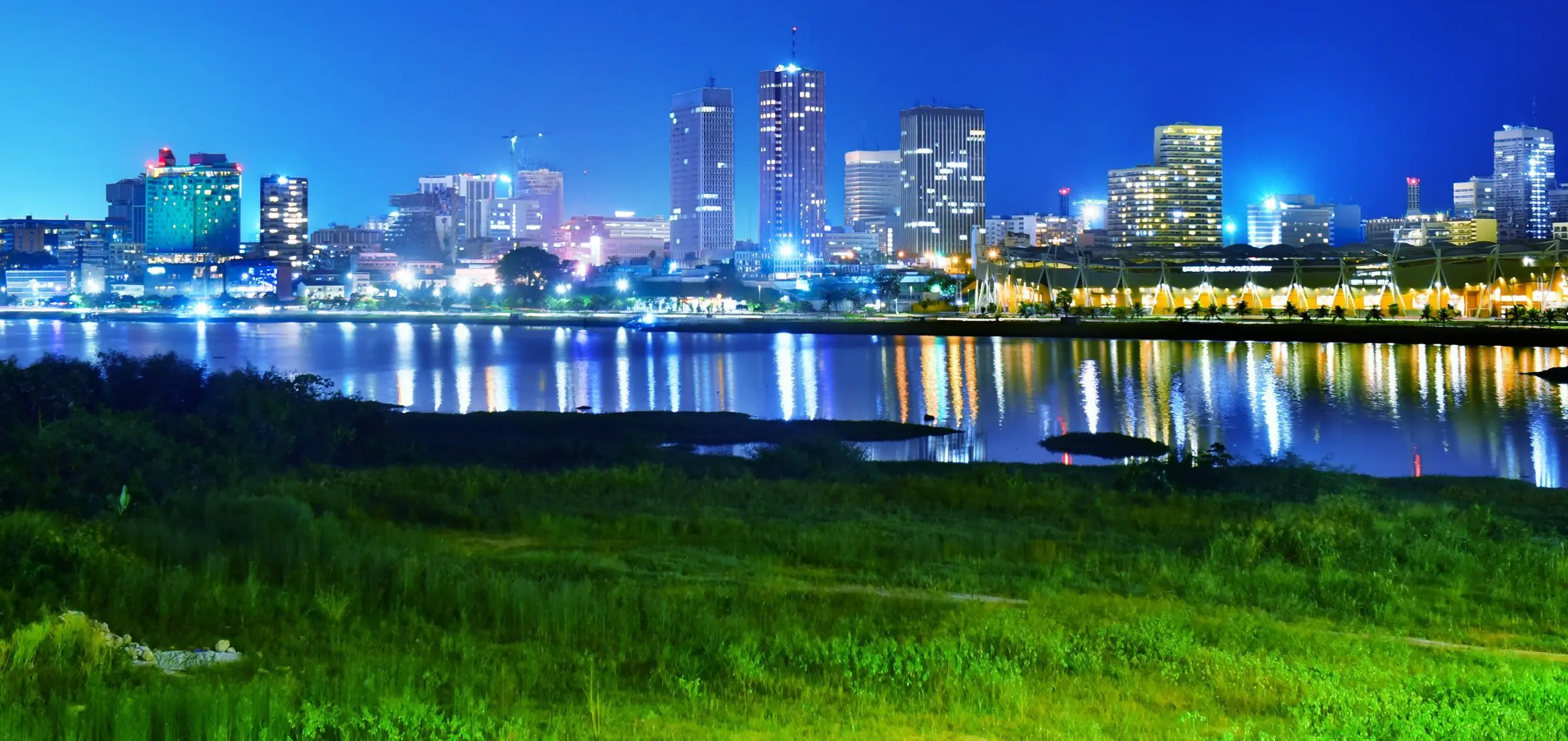 Les tours du Plateau illuminées au-dessus de la lagune Ébrié, à Abidjan, la nuit