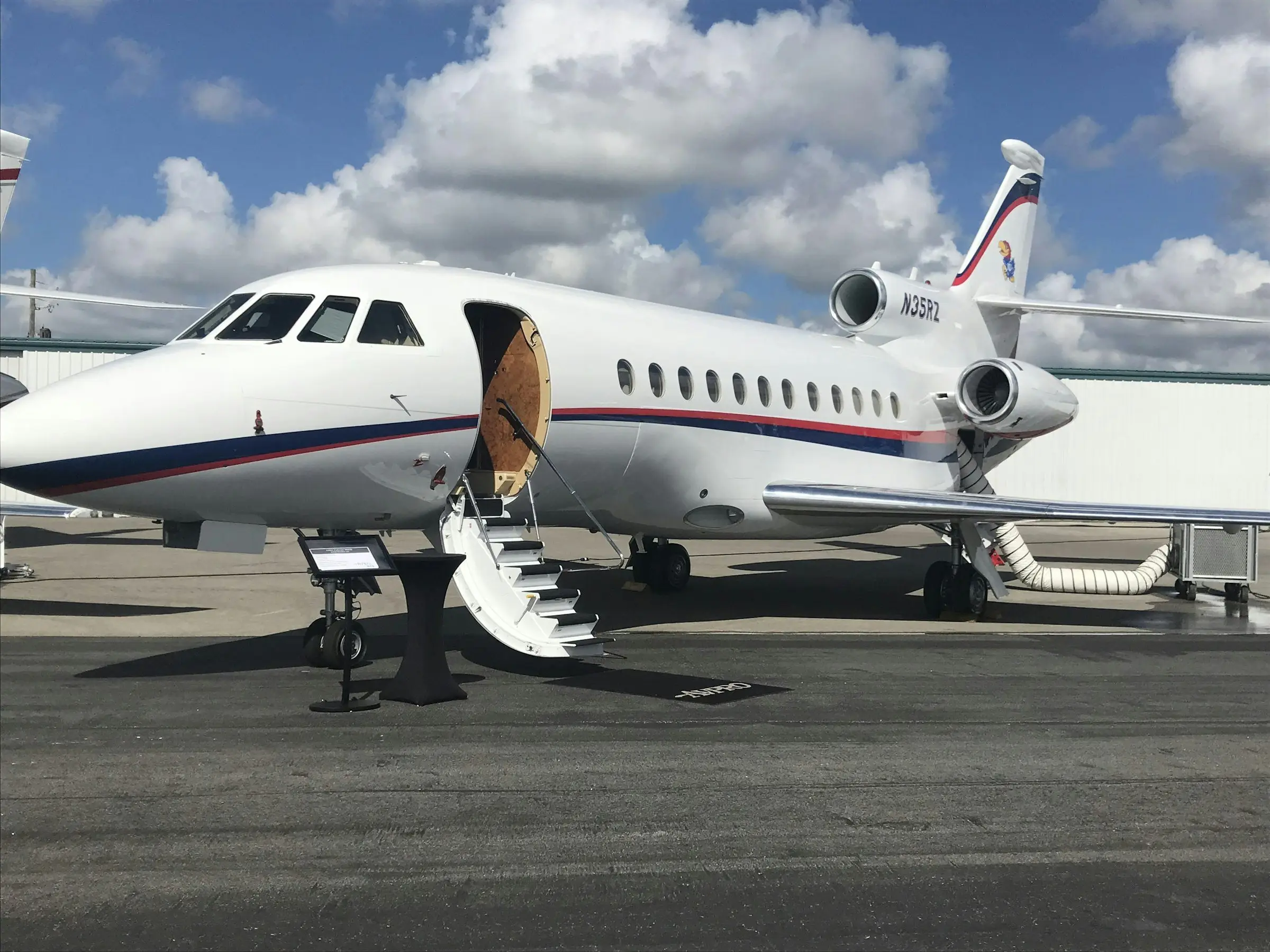 Jet privé sur le tarmac, escalier déployé pour l’embarquement d’une équipe